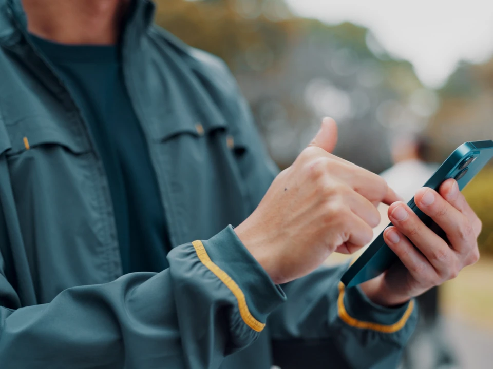 Électricien professionnel en extérieur près de son fourgon utilitaire blanc, portant casque de sécurité blanc et gants de protection