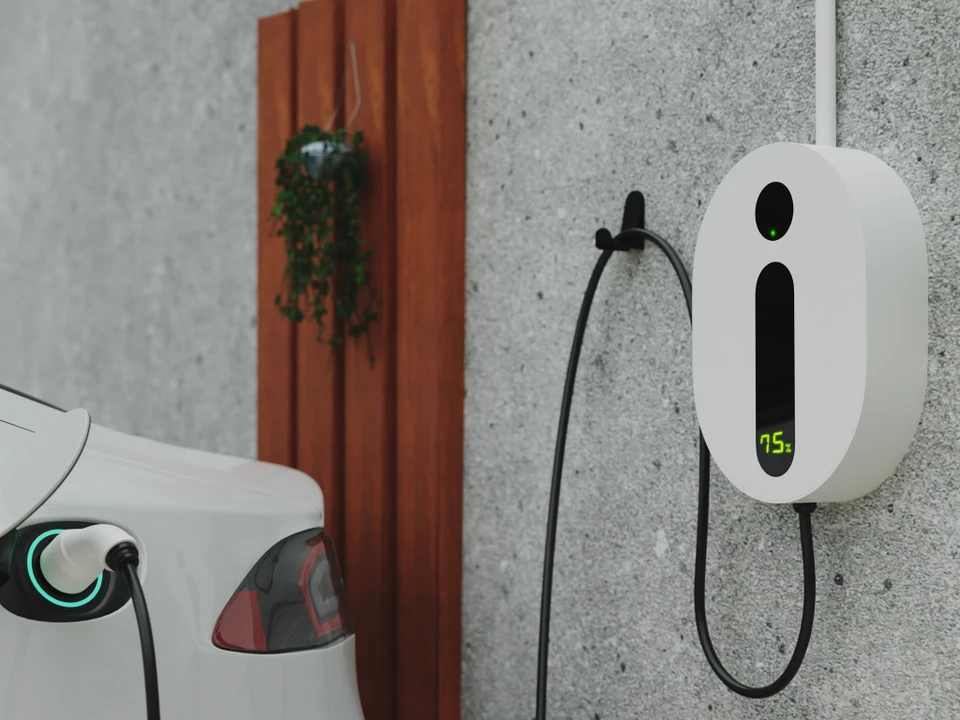 Un électricien travaille dans un tableau électrique ouvert, manipulant des fils avec un outil de précision