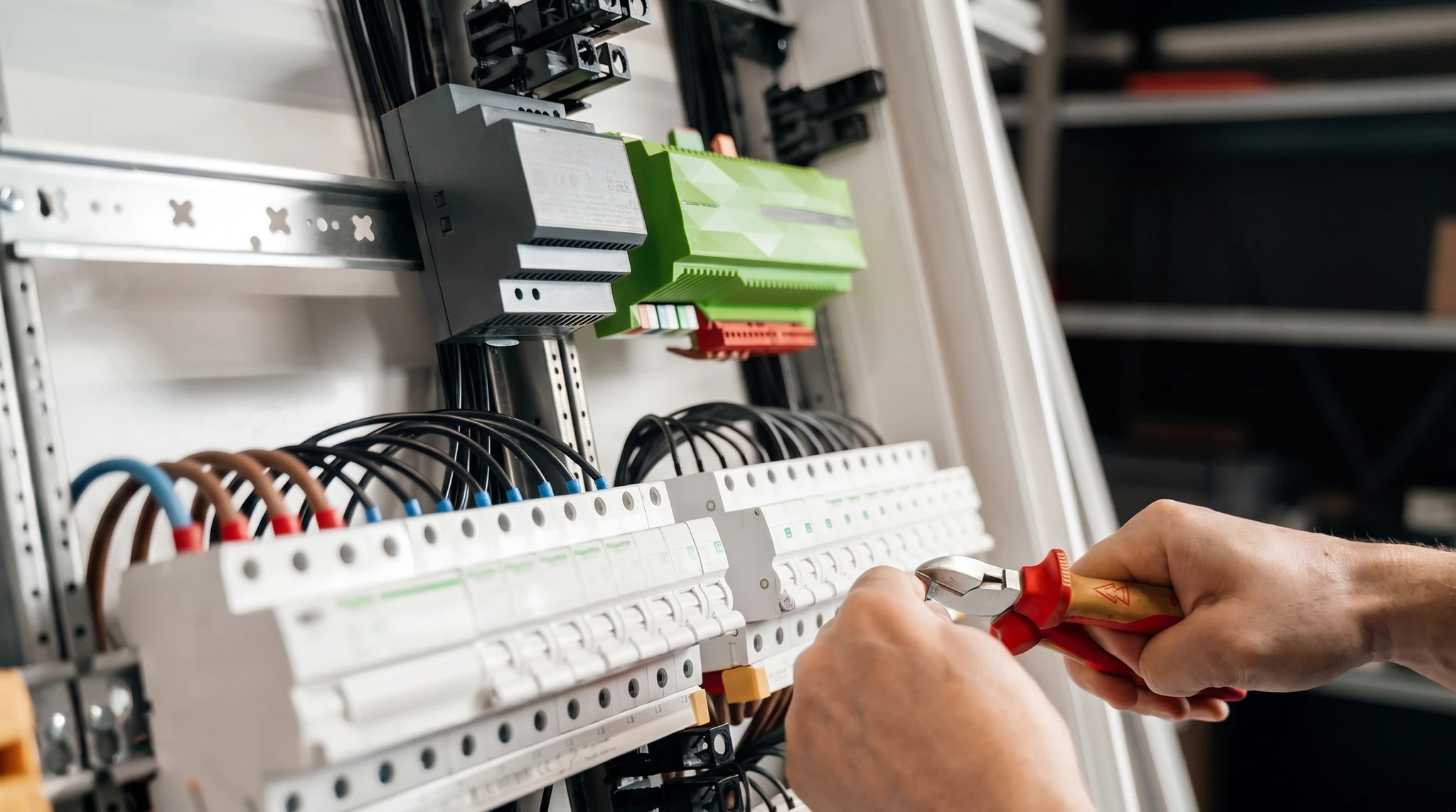 Électricien professionnel effectuant des mesures électriques dans un intérieur résidentiel